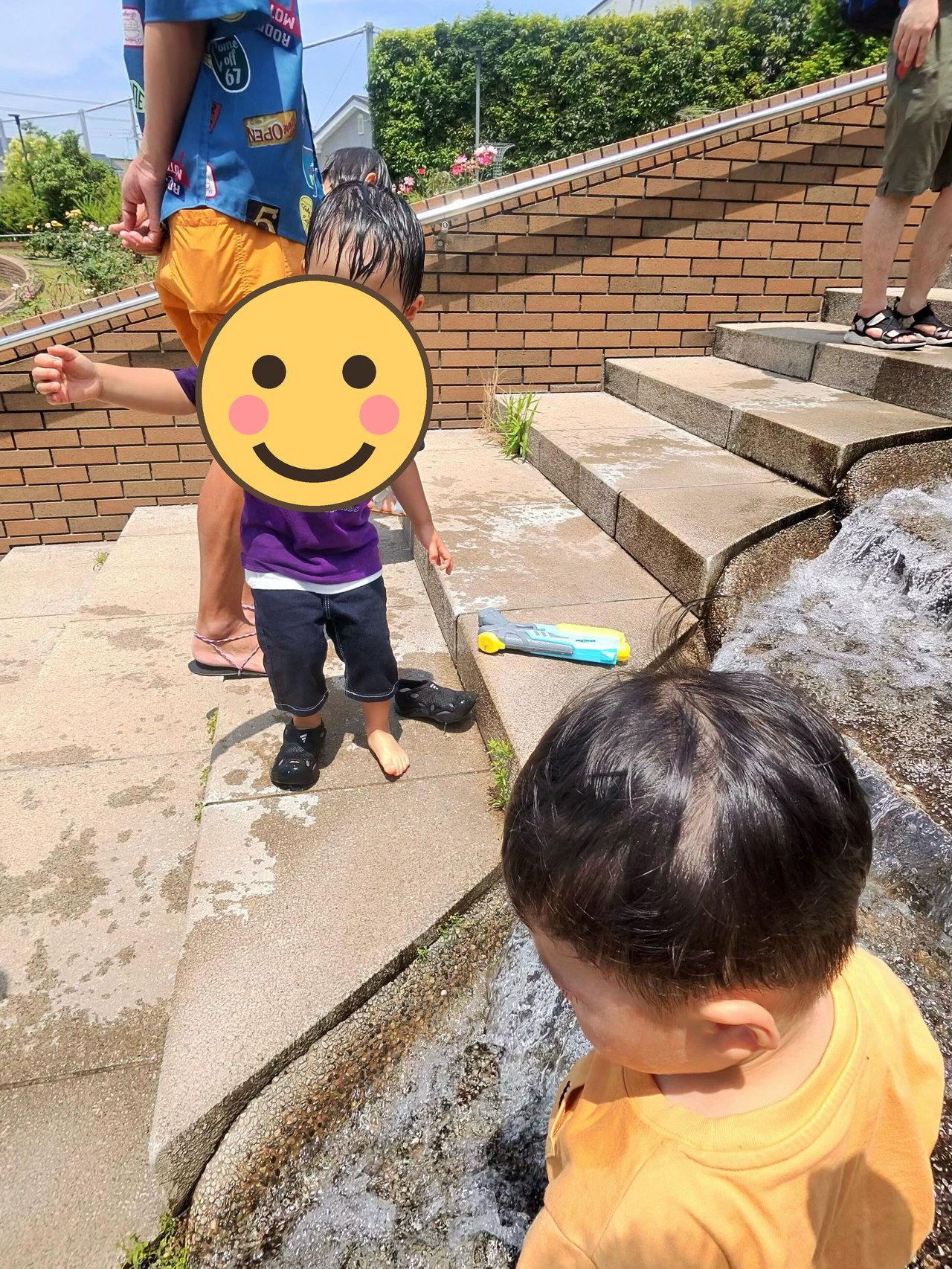 浅い流れでおもちゃの船で遊ぶ子ども