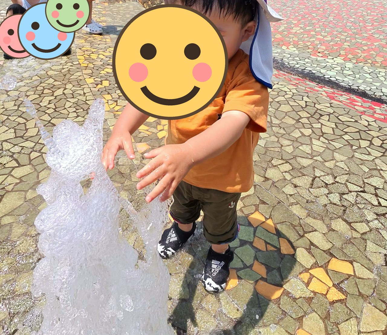 噴水の水に手を伸ばす子ども
